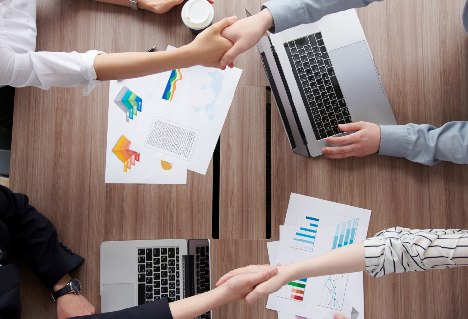 ノートパソコン、電卓、書類を使って業務を行う様子